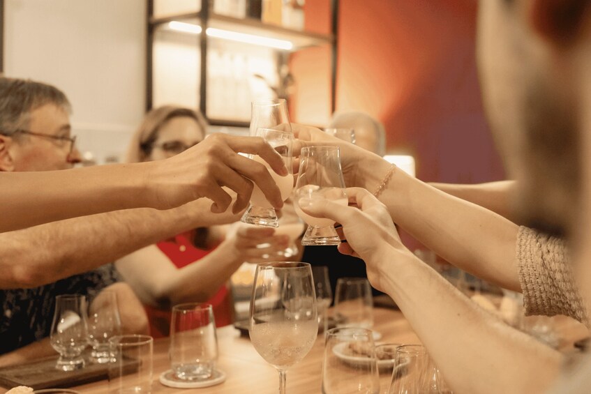 A group of people toasting with wine glasses at a table. 5