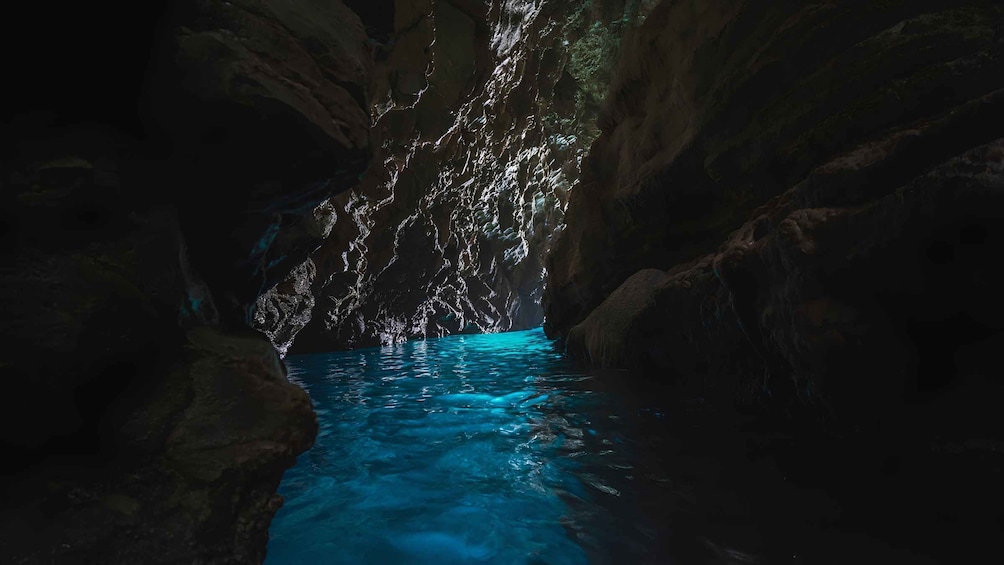 A cave with a blue pool and rock formations. 2
