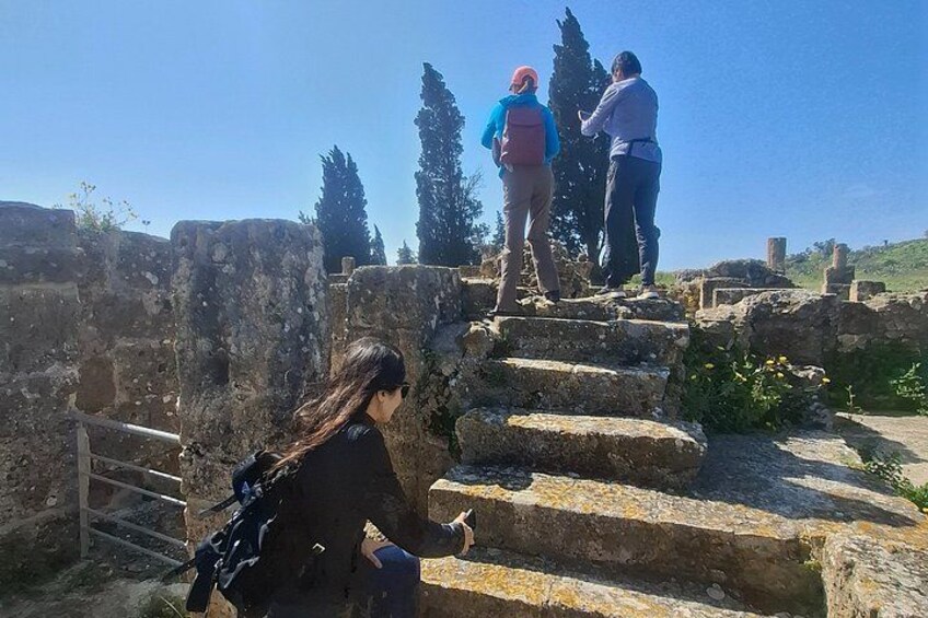 People exploring ancient ruins with stone steps and columns. 2