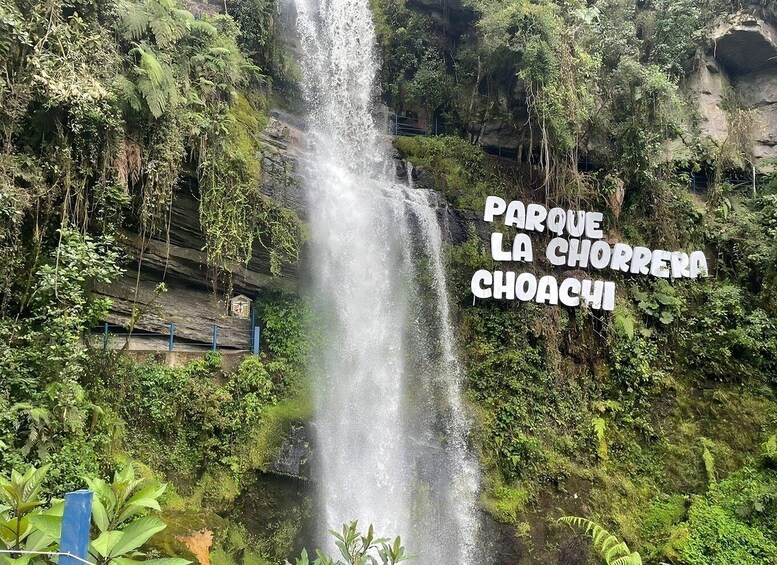 A waterfall in a lush, green park with a sign reading "Parque La Chorrera Choachi". 3