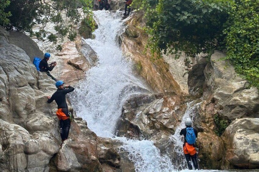 A group of people kayaking on a river surrounded by rocky terrain. 5