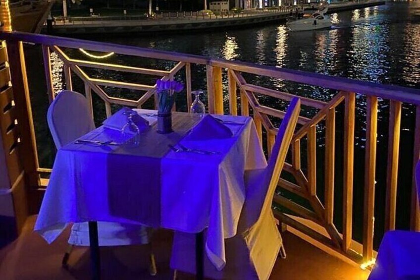 A table set for dining with a view of a river at night. 3
