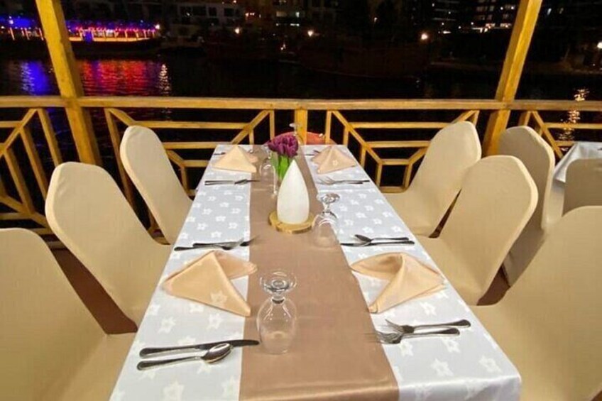A dining table set for six with a white tablecloth, a vase with flowers, and a bottle of water. 5