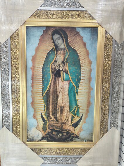 A framed religious painting with a central figure, surrounded by ornate golden borders. 2