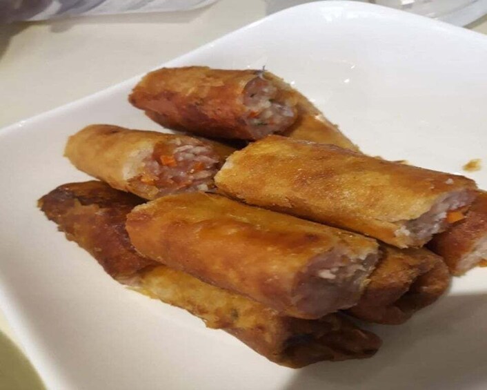 A white plate with several fried spring rolls. 4