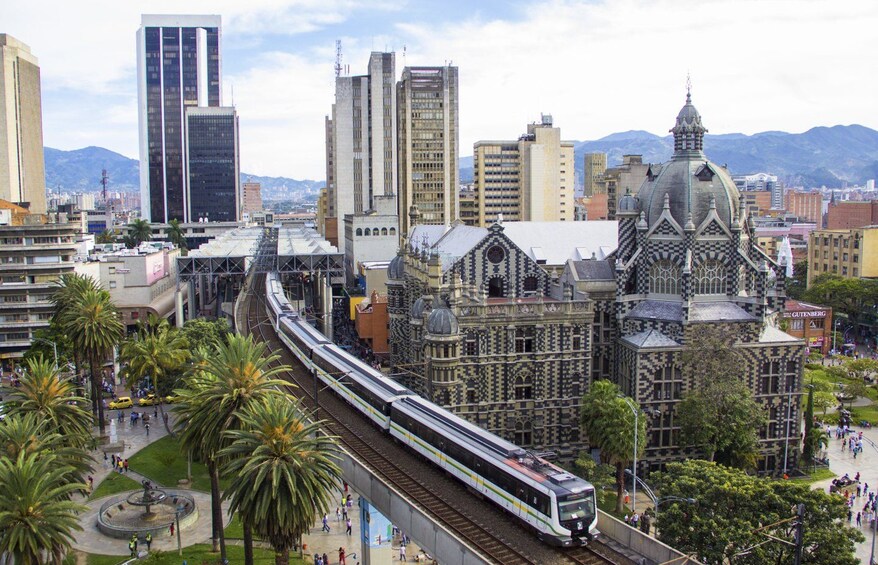 A modern train on tracks, a historic building with intricate architecture, and a cityscape with tall buildings. 3