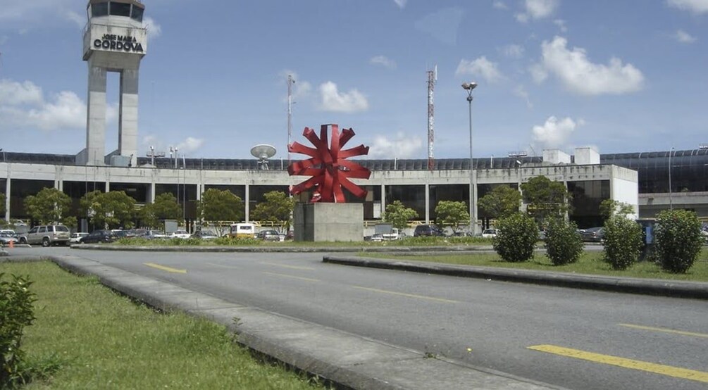 A large red sculpture in front of a building with a control tower. 2