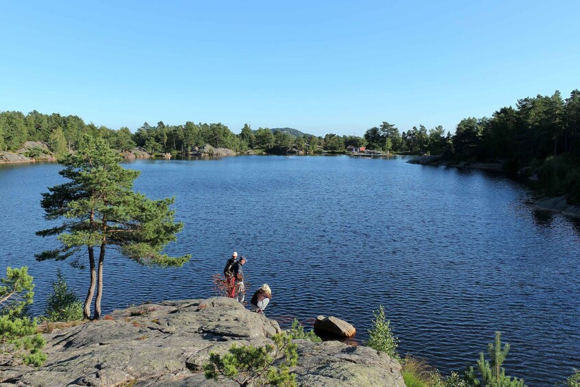 A calm lake surrounded by trees and rocks. 4