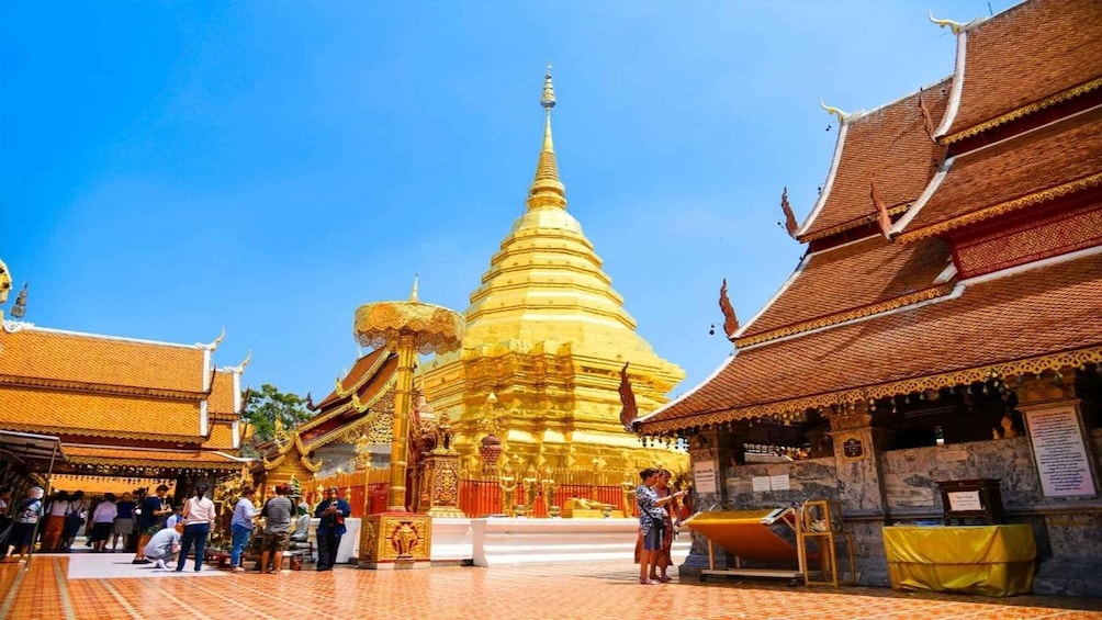 A golden stupa surrounded by traditional Thai architecture. 4