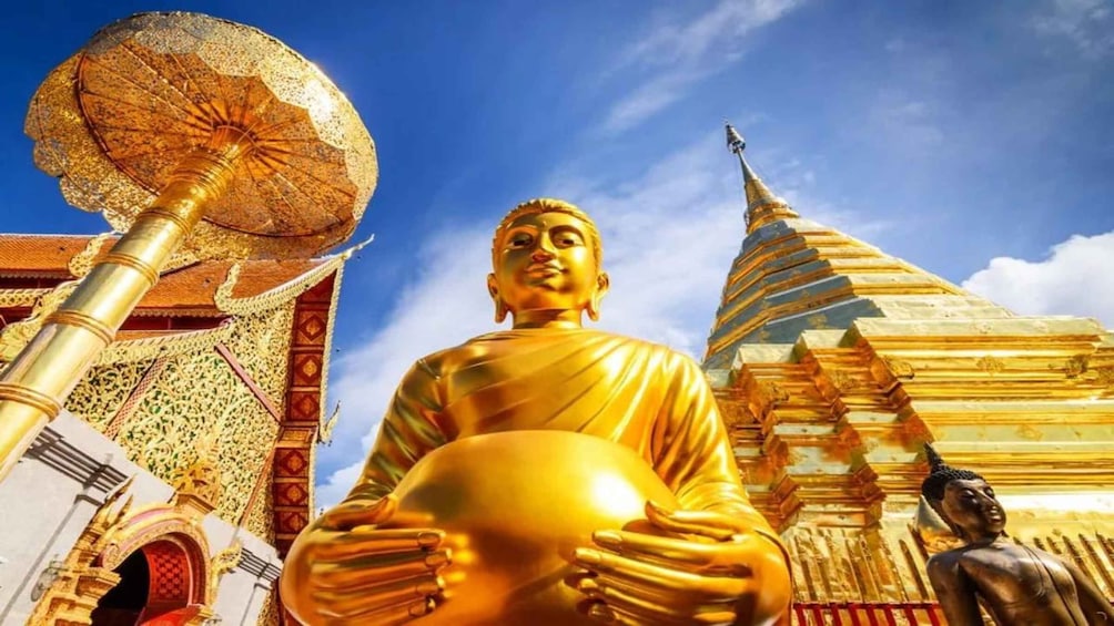 A golden Buddha statue in front of a temple with intricate architecture. 3