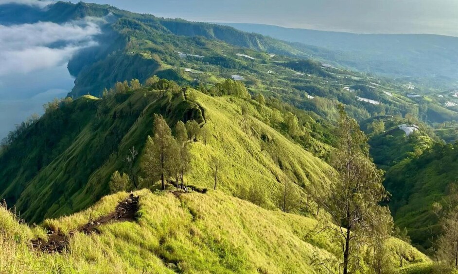 A lush green valley with rolling hills and a river. 3
