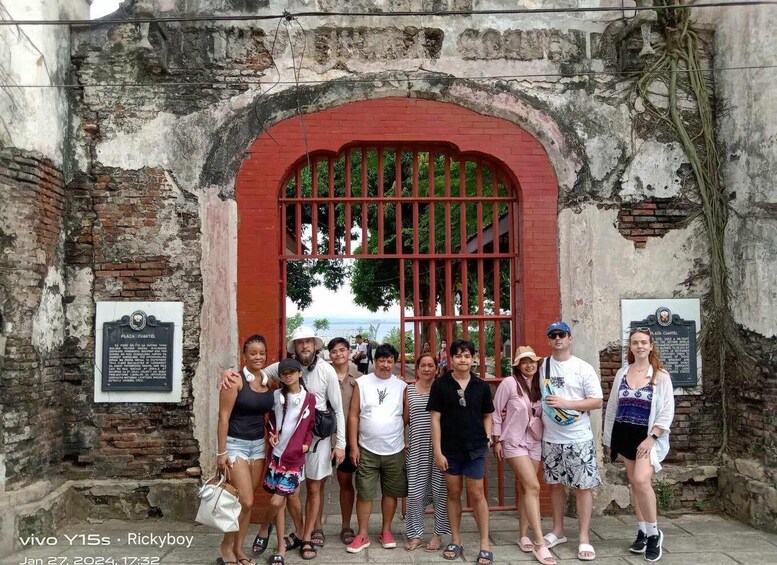 A group of people standing in front of a historic gate with a plaque. 4