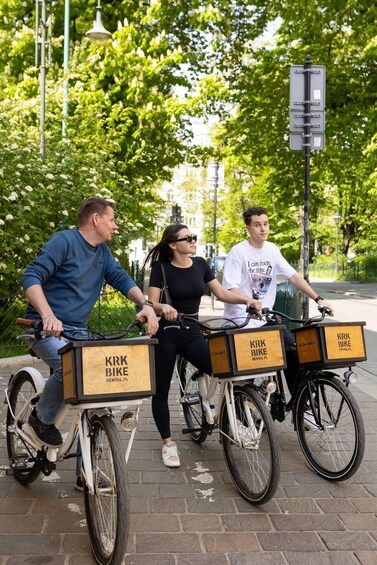 Kolme ihmistä ajaa polkupyörillä, ja pyörissä on «Kirk Bike Rental» -kyltit. 1