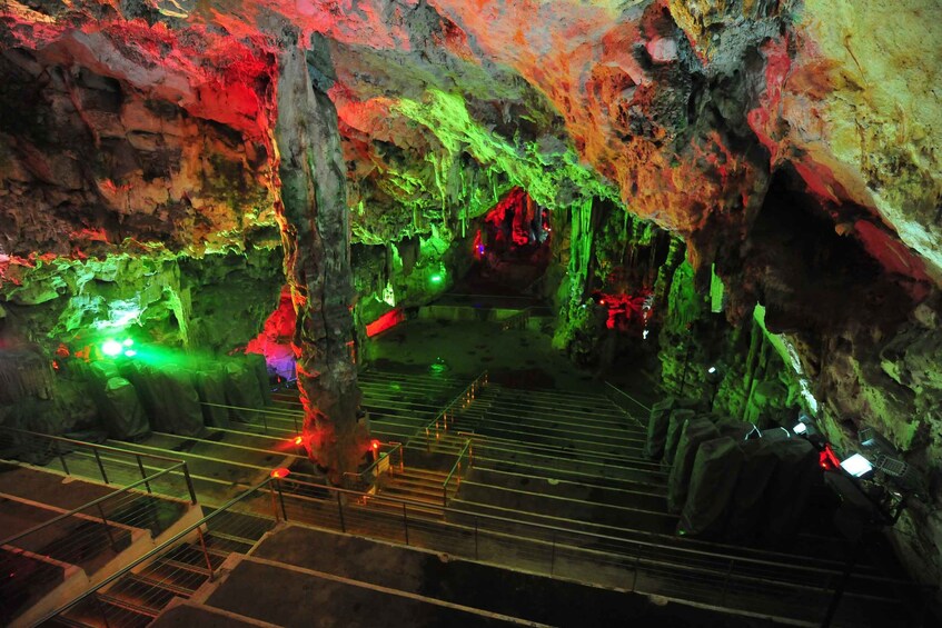 An illuminated cave with colorful lighting and a central staircase. 4