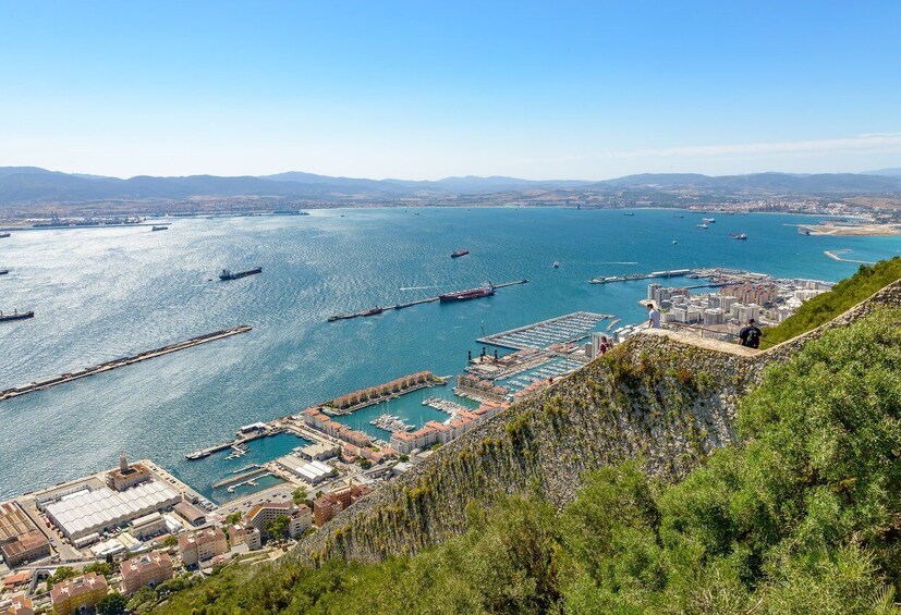 A coastal cityscape with a marina, boats, and industrial buildings. 5