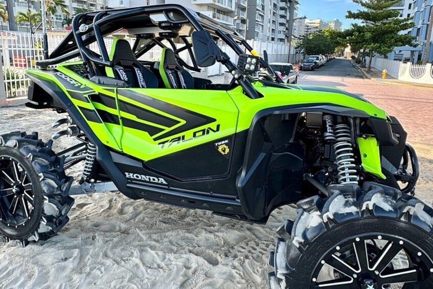 En grøn og sort Honda ATV med store dæk og forrude. 5