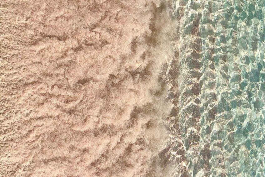 A sandy beach with clear turquoise water. 3