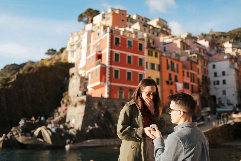 Un couple se tenant la main près de bâtiments colorés, au bord de l’eau. 3