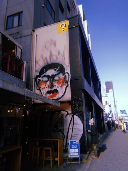 A building with a large mural of a face and a sign that says "Made in Paradise". 2