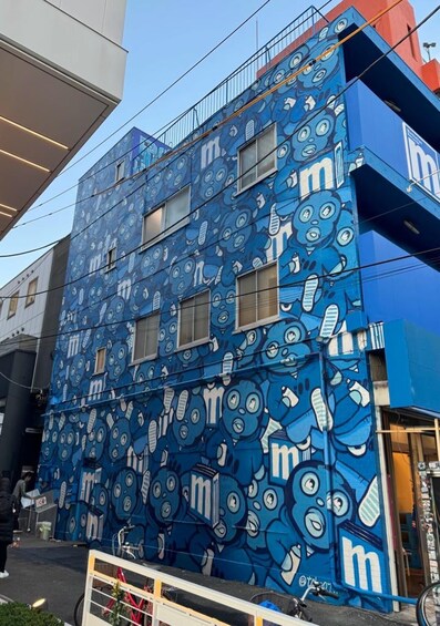 A building with a blue exterior and a mural of blue cartoon characters. 5
