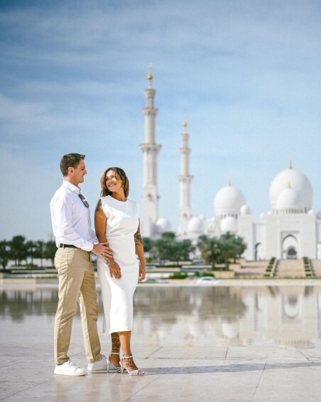 A couple standing in front of a mosque with minarets and domes. 4