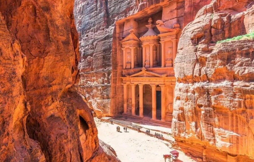 A rock-cut architectural structure with columns and a facade, surrounded by red sandstone cliffs. 4
