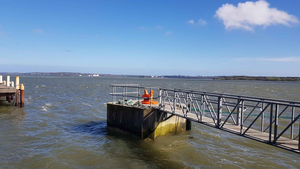 A pier extending into a body of water with a metal railing and a concrete platform. 2