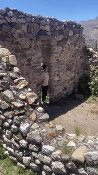 A stone structure with a person standing in front. 2