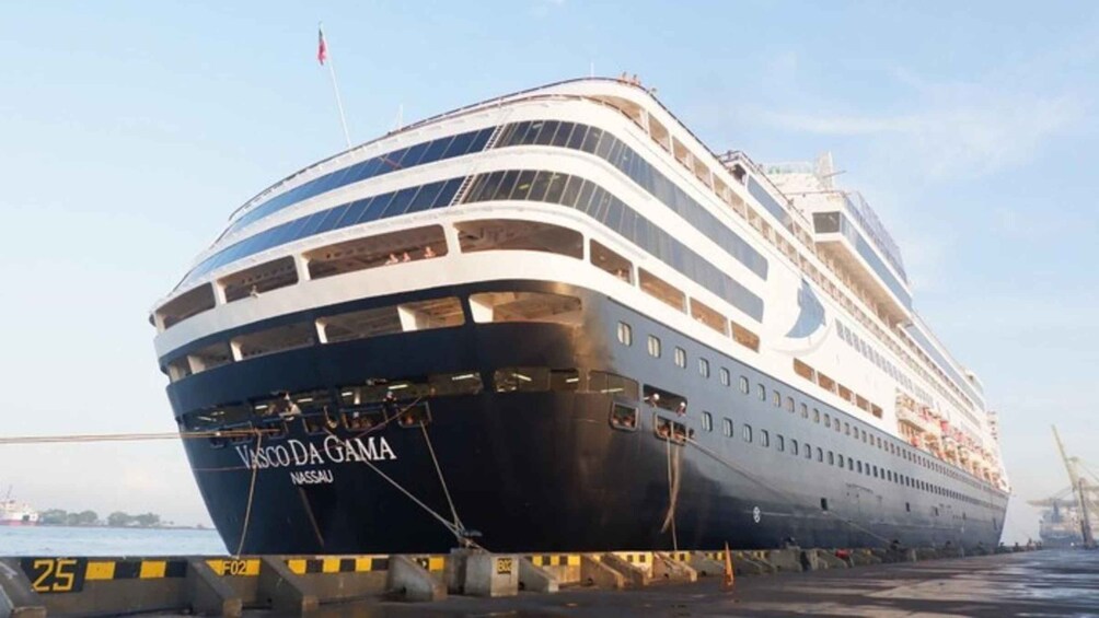 A large cruise ship named Vasco da Gama docked at a port. 1