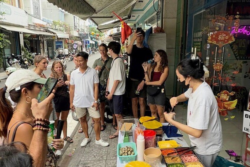 A street food vendor serving customers at a food stall. 2