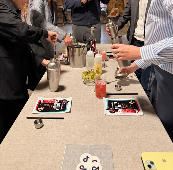 A bar setting with a bartender preparing drinks, a bottle of red wine, and a menu on the table. 3