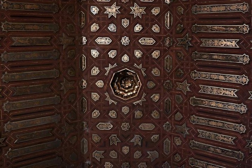 A detailed ceiling with geometric patterns and star motifs. 3