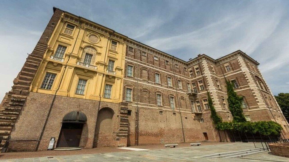 A large, historic building with a yellow facade and a brick exterior. 4