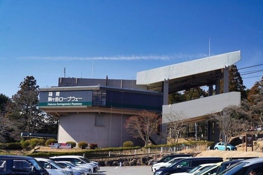 Un bâtiment moderne, orné d’une enseigne en japonais, entouré de voitures garées et d’arbres. 5