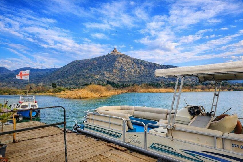 A boat docked at a wooden pier with a mountainous backdrop. 5