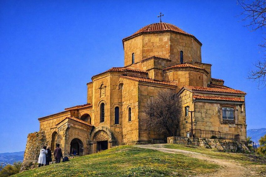 A historic church with a red-tiled roof, arched windows, and a bell tower. 3