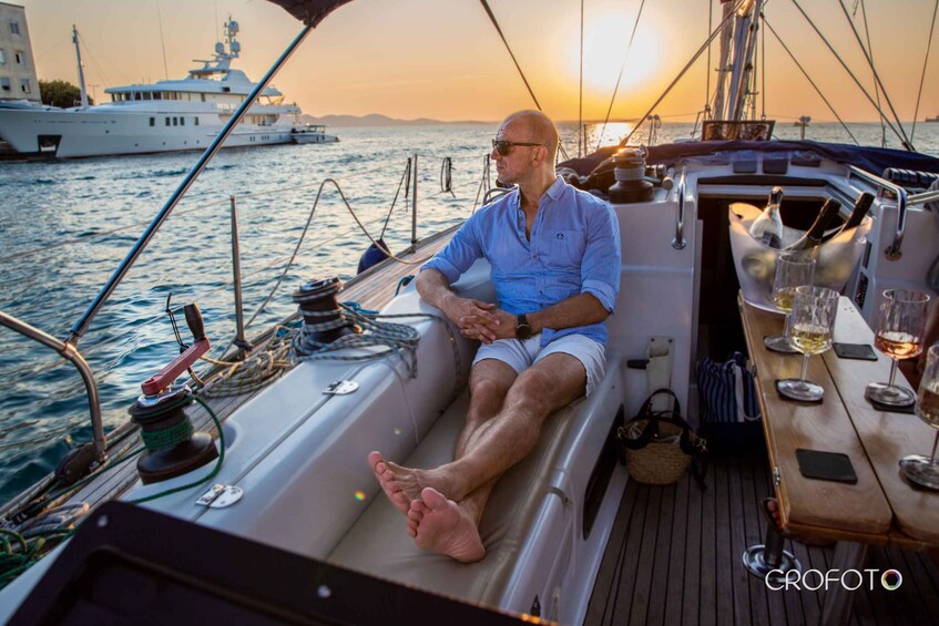 A man sitting on a boat deck during sunset. 5