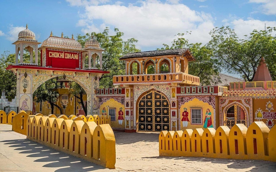 A colorful building with intricate designs and the name "Chokhi Dhani". 1