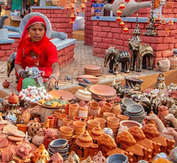 A woman selling pottery and figurines at a market stall. 5