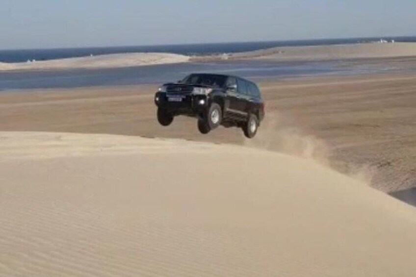 Un véhicule circulant sur des dunes de sable près d’une plage. 2