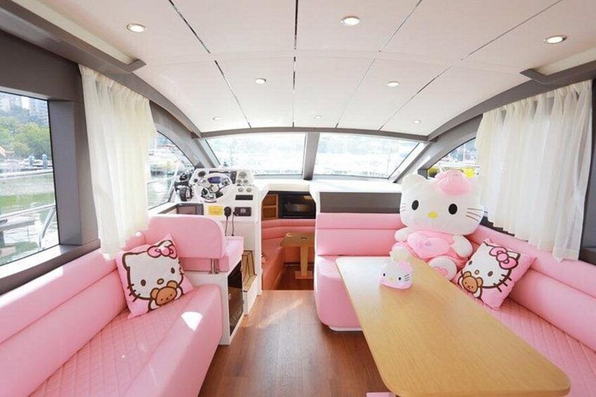 Un interior decorado en tonos rosados con un peluche grande de Hello Kitty. 3