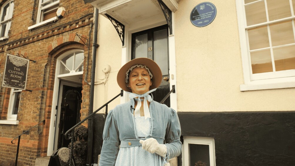 A person in historical attire standing in front of a building with a sign reading 'The Cutting Room.' 3