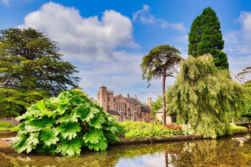 A historic building with a moat and lush greenery. 5