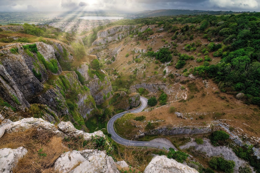 A winding road through a rocky canyon with greenery on the sides. 1