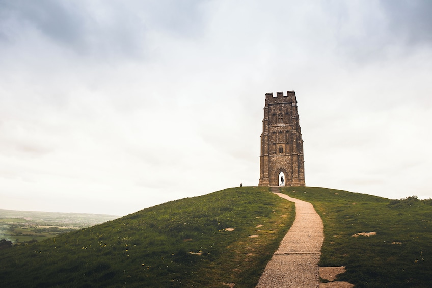 A tower on a grassy hill with a path leading to it. 4