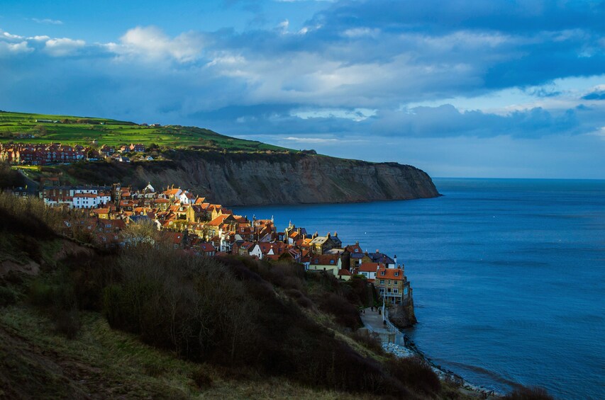 A coastal town with red-roofed houses on a cliff overlooking the sea. 4