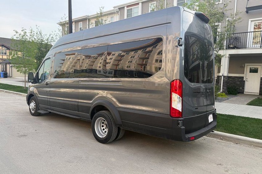 Una camioneta gris estacionada en una calle residencial con casas al fondo. 2