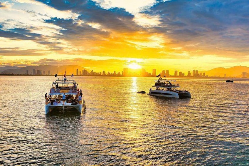 Two boats on a body of water with a sunset in the background. 1