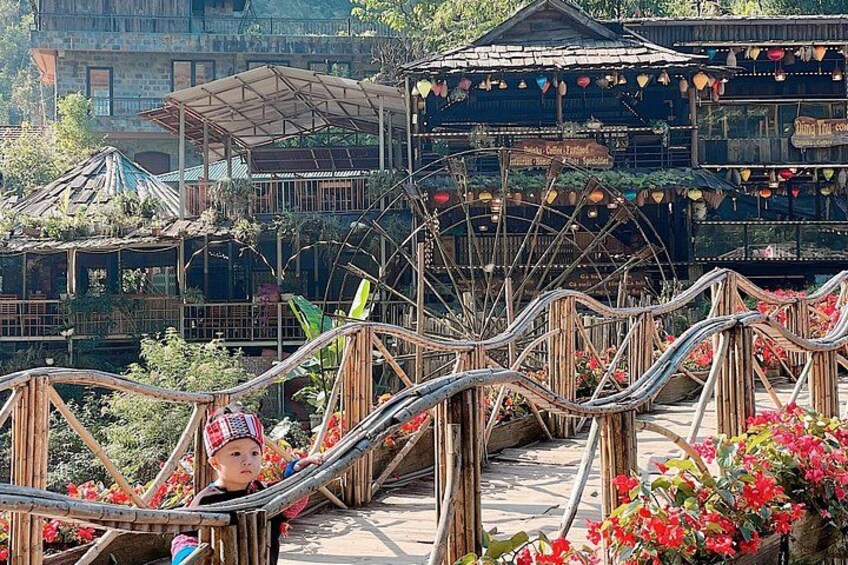 A wooden bridge with a person lying on it, surrounded by flowers and a large Ferris wheel in the background. 5