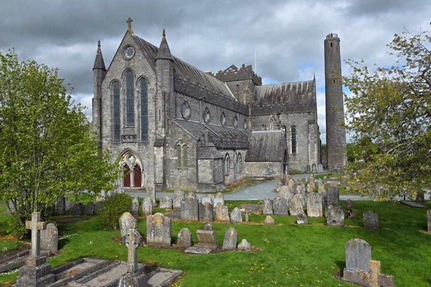 A historic church with a tall tower and a graveyard in front. 3